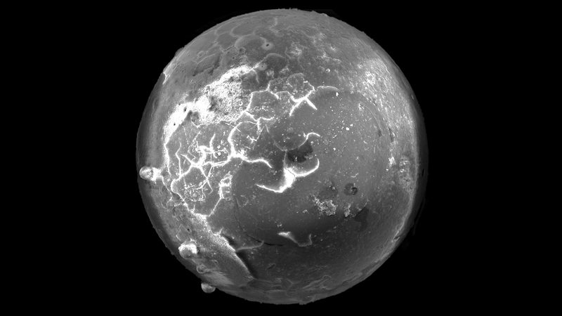 A microtektite seen through a microscope.